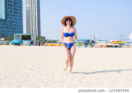 Girl in blue bikini runs along the beach to her beloved man Girl in blue bikini runs along the beach to her beloved man 123395344