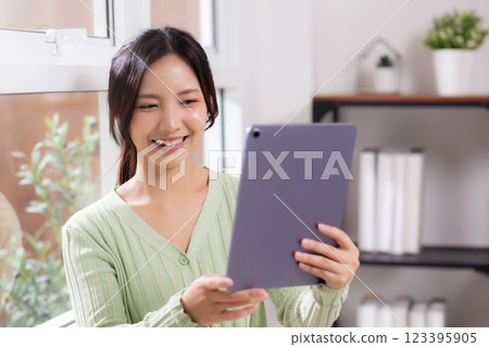 Portrait young asian business woman using digital tablet computer for video call by the window. Portrait young asian business woman using digital tablet computer for video call by the window. 123395905