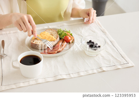 Woman eating breakfast in the dining room Woman eating breakfast in the dining room 123395953
