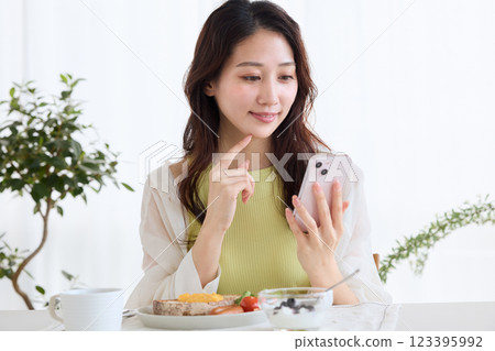 Woman eating breakfast in the dining room 123395992