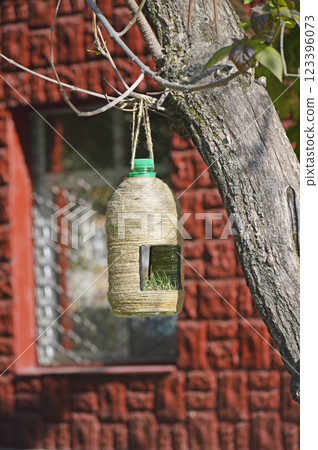 bird feeder made from a large plastic bottle in a city park bird feeder made from a large plastic bottle in a city park 123396073