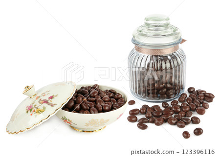 Chocolate dragee in vintage porcelain candy bowl and glass jar isolated on white. Chocolate dragee in vintage porcelain candy bowl and glass jar isolated on white. 123396116