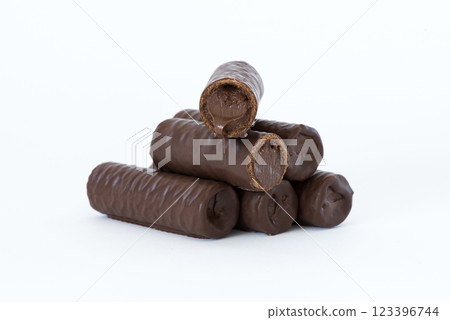 Sweet chocolate covered rolls - table arrangement, isolated on white background. Selective focus. Copy space. Sweet chocolate covered rolls - table arrangement, isolated on white background. Selective focus. Copy space. 123396744