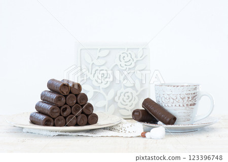 Sweet chocolate covered rolls - table arrangement, isolated on white background. Selective focus. Copy space. Sweet chocolate covered rolls - table arrangement, isolated on white background. Selective focus. Copy space. 123396748