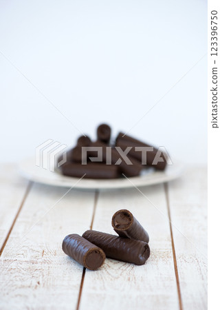 Sweet chocolate covered rolls - table arrangement, isolated on white background. Selective focus. Copy space. 123396750