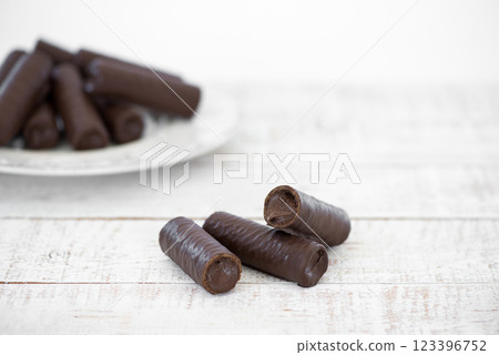 Sweet chocolate covered rolls - table arrangement, isolated on white background. Selective focus. Copy space. 123396752