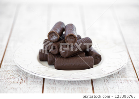 Sweet chocolate covered rolls - table arrangement, isolated on white background. Selective focus. Copy space. Sweet chocolate covered rolls - table arrangement, isolated on white background. Selective focus. Copy space. 123396763