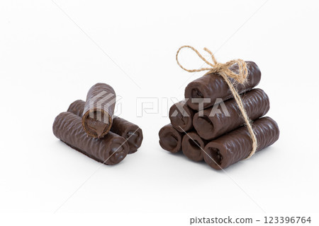 Sweet chocolate covered rolls - table arrangement, isolated on white background. Selective focus. Copy space. Sweet chocolate covered rolls - table arrangement, isolated on white background. Selective focus. Copy space. 123396764