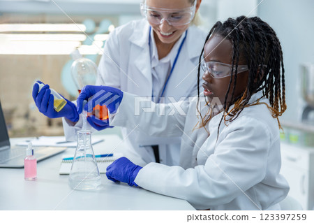 Two people working with the vacutainers in a school laboratory 123397259