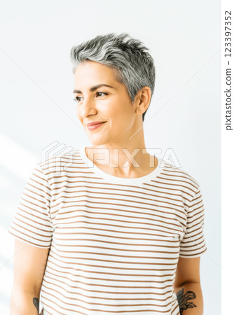 Mature woman with short gray hair in striped t-shirt smiling sideways Mature woman with short gray hair in striped t-shirt smiling sideways 123397352