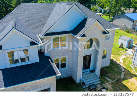 Aerial view of newly built residential property showcases contemporary architecture, spacious surroundings. 123397577