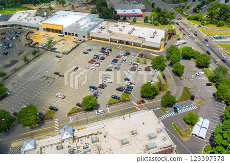 Vehicles occupy spaces in large parking lot surrounded by retail buildings near American town at New Jersey Vehicles occupy spaces in large parking lot surrounded by retail buildings near American town at New Jersey 123397578