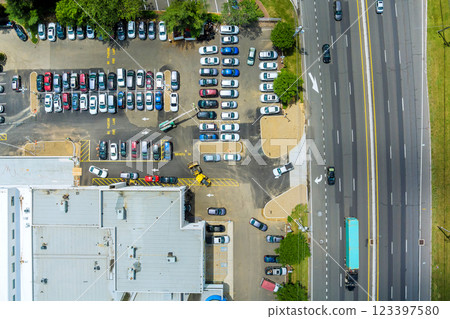 Cars are parked in lot adjacent to commercial building while traffic flows along road near American town at New Jersey Cars are parked in lot adjacent to commercial building while traffic flows along road near American town at New Jersey 123397580