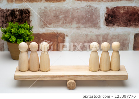 Three peg dolls on a seesaw Three peg dolls on a seesaw 123397770