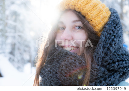 Happy smiling young woman in scarf and hat enjoying winter weather in snowy winter park 123397949