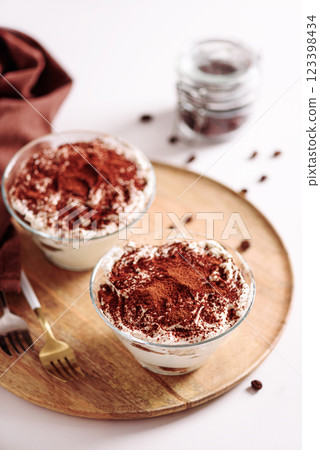 Traditional Italian dessert tiramisu in glasses on white table. Soft focus 123398434