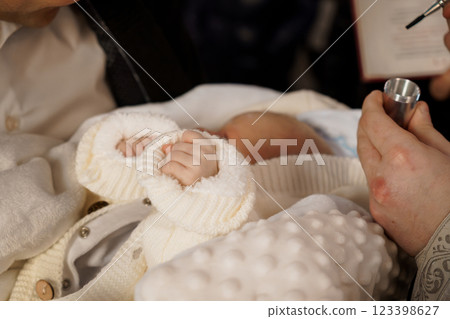 Newborn Baby in White Sweater during a Special Ceremony Newborn Baby in White Sweater during a Special Ceremony 123398627