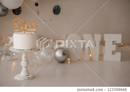 Elegant First Birthday Cake Display with Silver and White Decorations 123398666