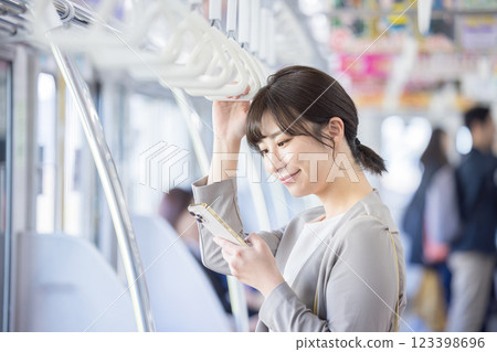 A woman looking at her smartphone on the train. Photo courtesy of Keio Corporation. A woman looking at her smartphone on the train. Photo courtesy of Keio Corporation. 123398696