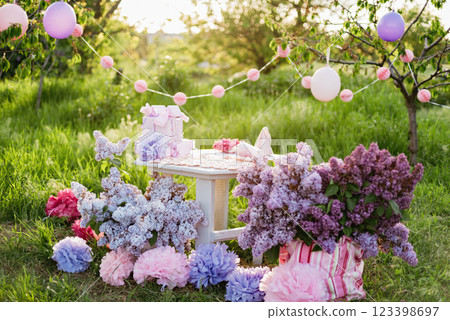 Summer outdoor kids birthday party background. Celebrating birthday in park. Kids party pink pastel decoration and food. Presents and sweets. 123398697