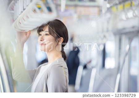 A woman looking at her smartphone on the train. Photo courtesy of Keio Corporation. 123398729