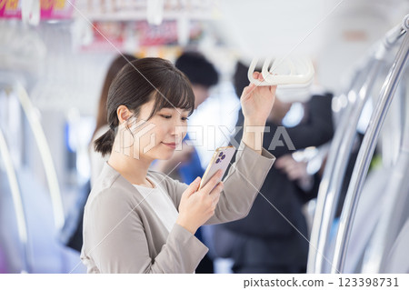 一名女子在火車上看她的智慧型手機。 123398731