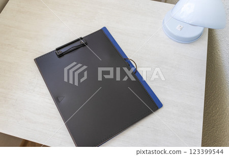 Shot of the plastic folder on the office desk with paper clip holder on the top and other office items. A4 size paper mock up. 123399544