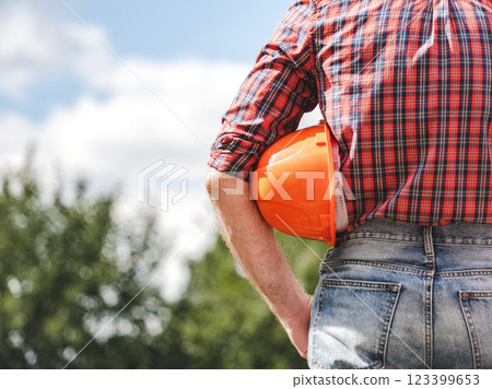 Attractive man in work clothes with a protective helmet Attractive man in work clothes with a protective helmet 123399653