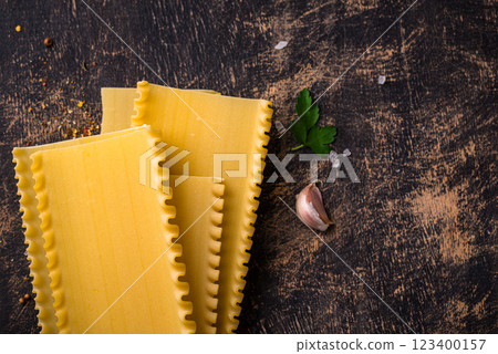 Uncooked lasagna pasta with cooking ingredient Uncooked lasagna pasta with cooking ingredient 123400157