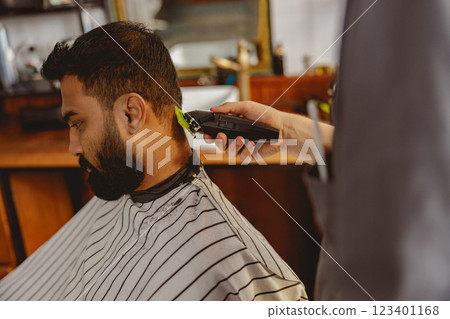 A gentleman is getting a modern haircut at a barbershop, focused on his grooming A gentleman is getting a modern haircut at a barbershop, focused on his grooming 123401168