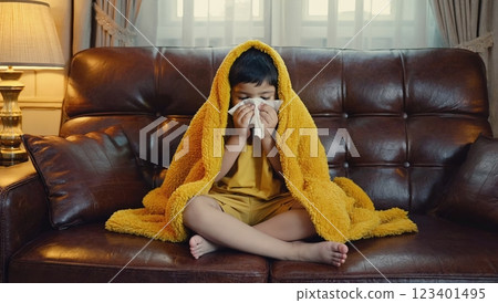 Sick girl sitting under blanket with flu symptoms Sick girl sitting under blanket with flu symptoms 123401495