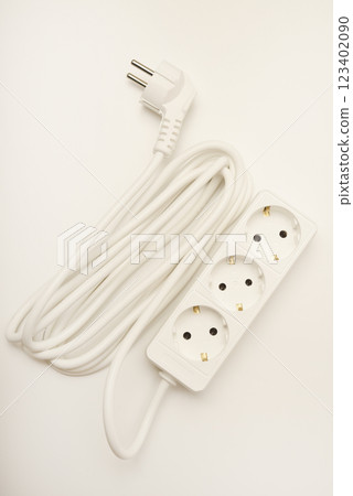 An extension cord with three sockets. White wire with sockets on a white background. An extension cord with three sockets. White wire with sockets on a white background. 123402090