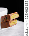 Dubai chocolate with pistachio filling on a white plate on a black background 123402122
