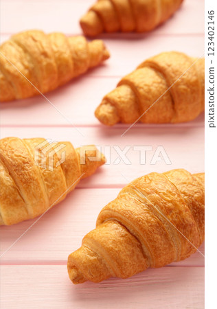 Freshly baked croissants on pink wooden background Warm Fresh Buttery Croissants and Rolls. French and American Croissants and Baked Pastries Freshly baked croissants on pink wooden background Warm Fresh Buttery Croissants and Rolls. French and American Croissants and Baked Pastries 123402146