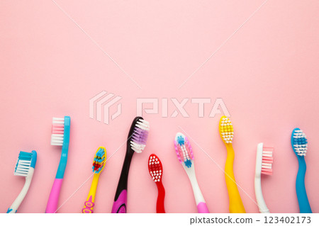 Colorful toothbrushes on pink background with copy space 123402173
