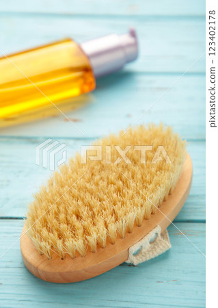 Set of home SPA cosmetic products. Dry Brush and Organic Oil. Anti-cellulite brush for dry body massage. Vertical photo 123402178
