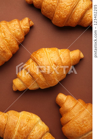 Freshly baked croissants on brown wooden background Warm Fresh Buttery Croissants and Rolls. French and American Croissants and Baked Pastries. Vertical photo. 123402205