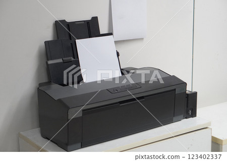 top view, old black plastic printer and white paper on white table, office background, technology, object, office, decor, comfortable, business, copy space 123402337