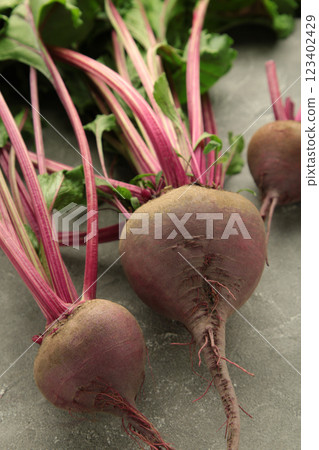 Red Beetroot with green leaves on grey background. Organic Beetroot. Vertical photo. Red Beetroot with green leaves on grey background. Organic Beetroot. Vertical photo. 123402429
