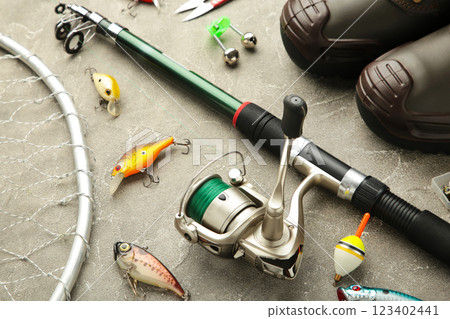 Nikolaev, Ukraine - 08 july, 2022: Fishing rods and spinnings in the composition with accessories for fishing on brown background. 123402441