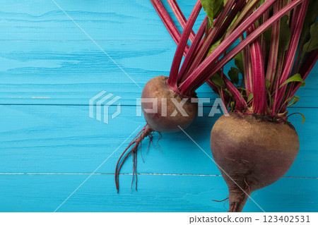 Red Beetroot with green leaves on blue background. Organic Beetroot. Vertical photo. Red Beetroot with green leaves on blue background. Organic Beetroot. Vertical photo. 123402531