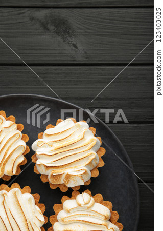 Appetizing lemon cupcakes with white cream on dark background. Holiday, surprise, birthday, Valentine's Day. Vertical photo Appetizing lemon cupcakes with white cream on dark background. Holiday, surprise, birthday, Valentine's Day. Vertical photo 123403025