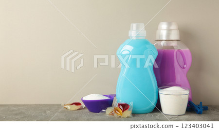 Laundry detergents with washing powder and capsules on grey background. Space for text Laundry detergents with washing powder and capsules on grey background. Space for text 123403041