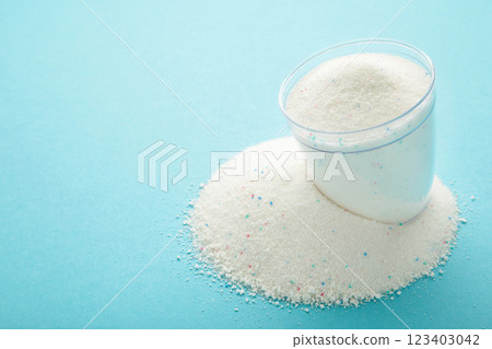 Washing powder in a measuring cup on a blue background Washing powder in a measuring cup on a blue background 123403042