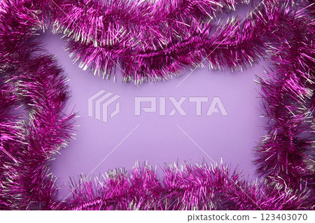 New years pink tinsel. Christmas theme on purple background. 123403070