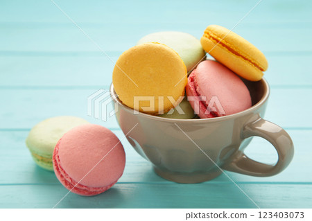 French macarons in cup on blue wooden background. 123403073