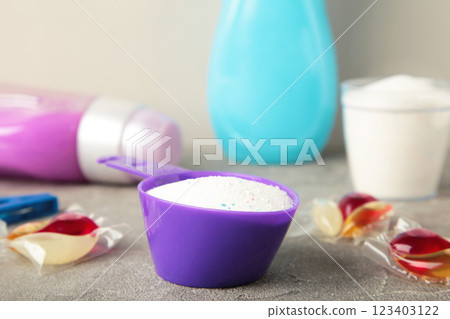 Laundry detergents with washing powder and capsules on grey background 123403122