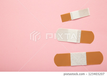 Adhesive bandage sticking plaster on pink background. Space for text 123403207