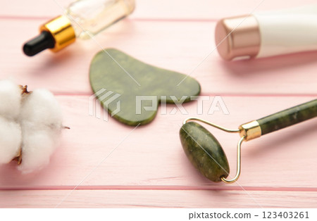 Jade facial roller on pink background with copy space Jade facial roller on pink background with copy space 123403261