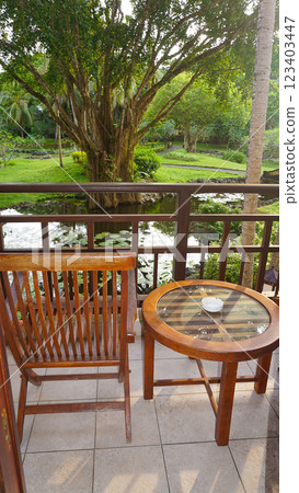 Cozy wooden house balcony with with tropical tree, Bali, Indonesia Cozy wooden house balcony with with tropical tree, Bali, Indonesia 123403447